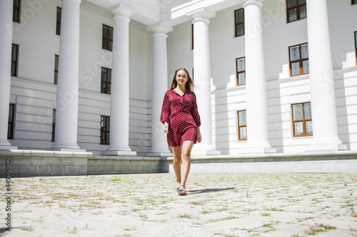 Portrait of a young beautiful blonde woman in a summer burgundy dress © Andrey_Arkusha