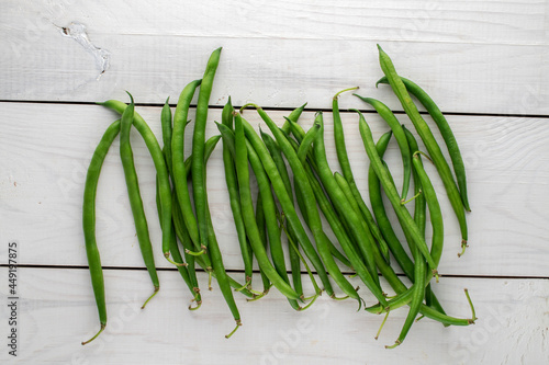 Several organic ripe green beans on a wooden table, close-up, top view.