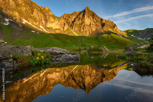 peak of Hochstollen with reflection in alpine lake near Melchseefrutt at sunrise in the swiss alps photo