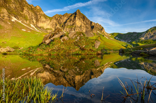 Fototapeta Naklejka Na Ścianę i Meble -  peak of Hochstollen with reflection in alpine lake near Melchseefrutt at sunrise in the swiss alps