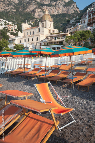 Positano, Salerno. Spiaggia del Fornillo con sedie a sdraio, ombrelloni e chiesa di Santa Maria Assunta