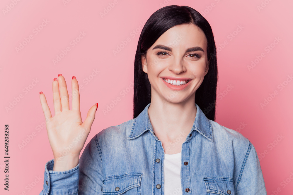 Portrait of female student waving hand happy positive smiling isolated on pastel pink color background Portrait of female student waving hand happy positive smiling isolated on pastel pink color background