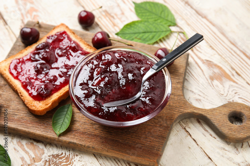 Obraz na plátně Bowl and toast with cherry jam on wooden background