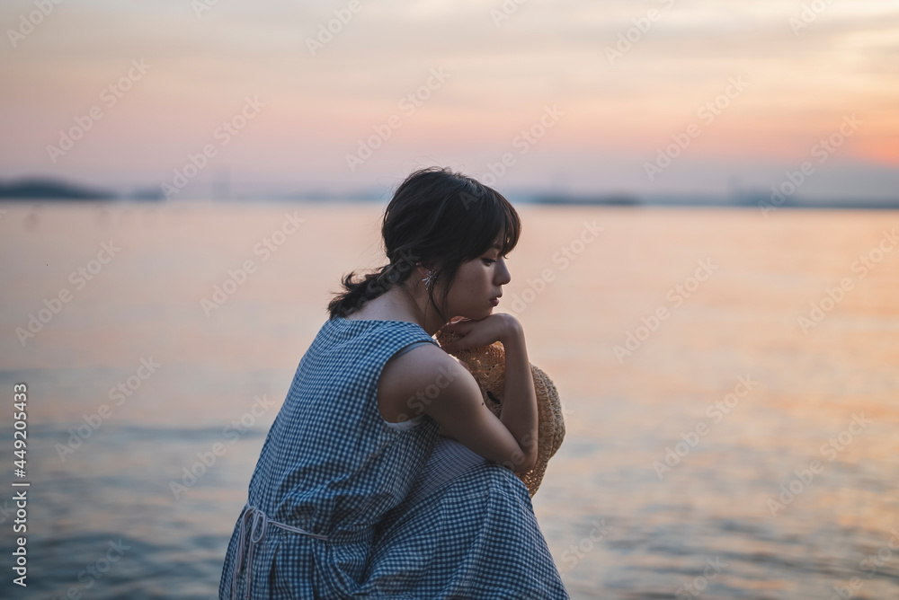 夕暮れの海にいる女性