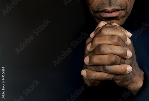 man praying to god with hands together Caribbean man praying on black background with people stock photos stock photo