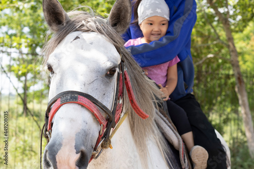 Man riding horse with daughter. Kazakh learns to ride. Ranch concept. Kazakhstan