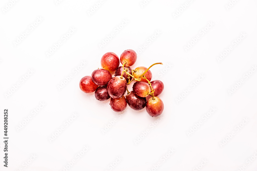 Small bunch of light red grapes viewed from the top on white background