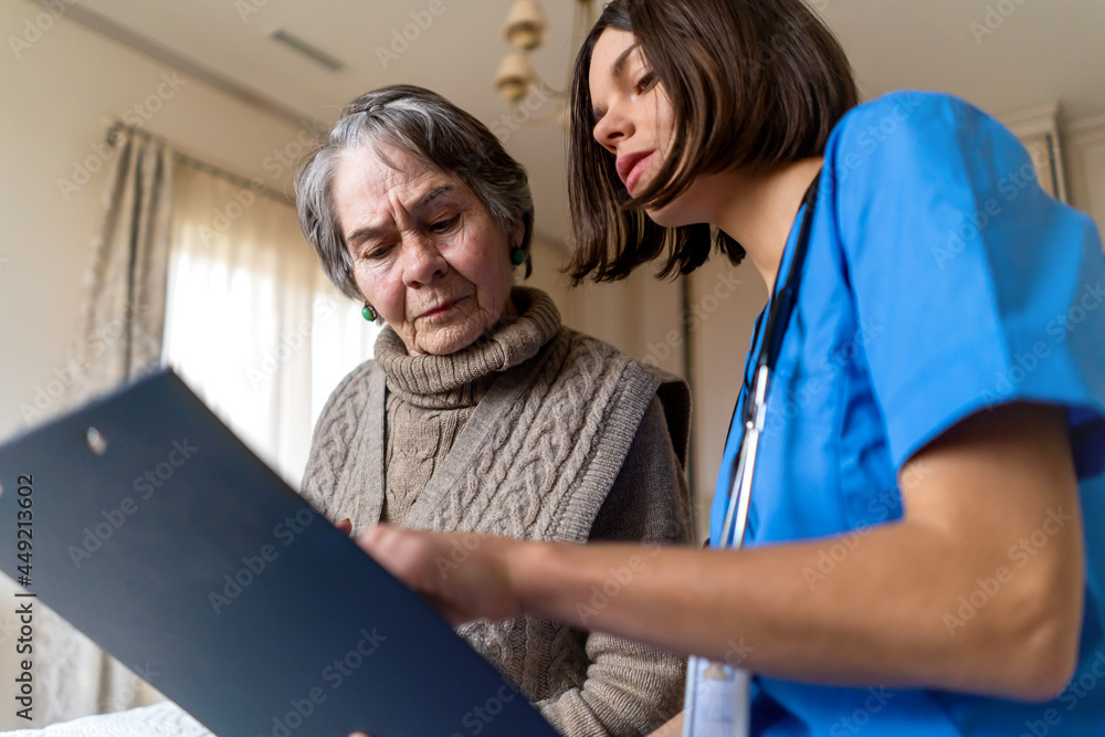 A young nurse takes care of an elderly 80-year-old woman at home A young nurse takes care of an elderly 80-year-old woman at home