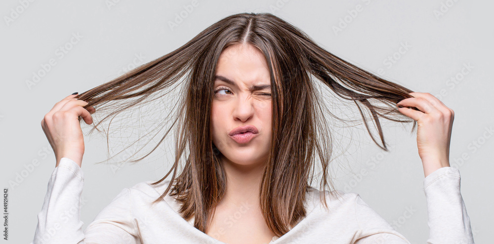 Fototapeta premium Girl having a bad hair. Bad hairs day. Frustrated woman having a bad hair. Woman having a bad hair, her hair is messy and tangled
