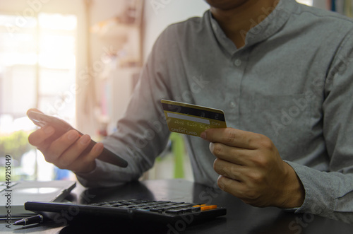 Man holding a credit card and a cell phone to pay for goods or services online or shopping online. concept financial business