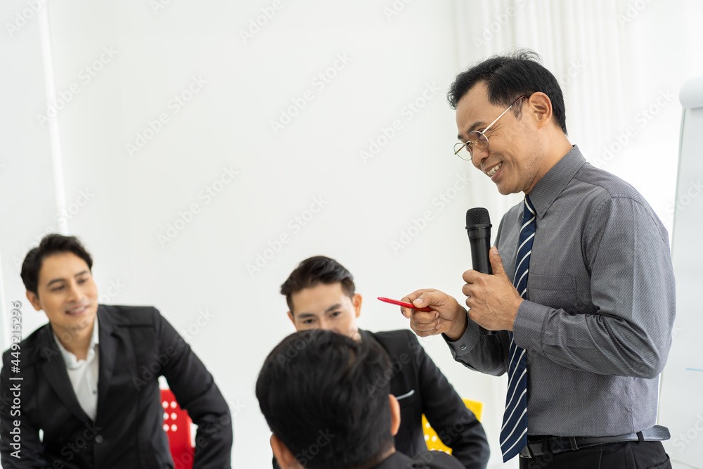 Senior Asian businessman discussion to colleagues in the meeting room. Business team or business partners sharing or brainstorming ideas together. business, people, investment concept Senior Asian businessman discussion to colleagues in the meeting room. Business team or business partners sharing or brainstorming ideas together. business, people, investment concept