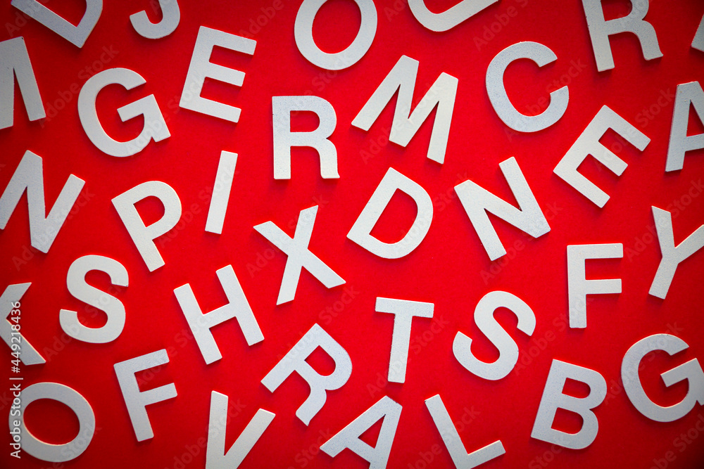 Mixed letters pile top view photo. Red background