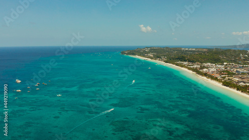 Tropical white beach with tourists and hotels near the blue sea, aerial view. Summer and travel vacation concept. © Alex Traveler