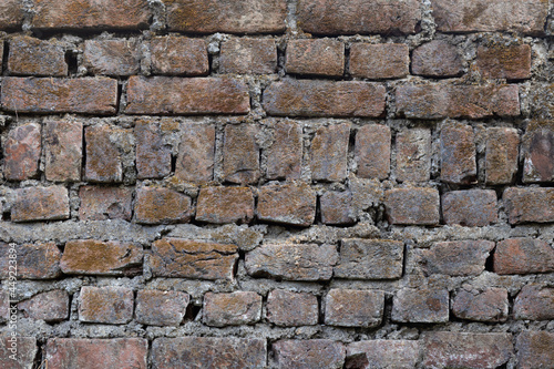A weathered and old brick wall with similar pattern as a background