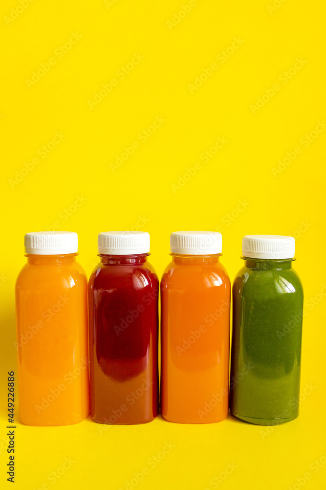 Fresh juices or smoothies of fruits and vegetables in bottles on a yellow background. The concept of a healthy diet, diet or detox Fresh juices or smoothies of fruits and vegetables in bottles on a yellow background. The concept of a healthy diet, diet or detox