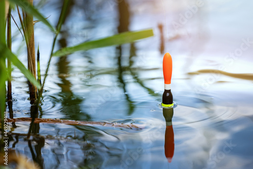 angling - fishing float in the pond water. catch the fish with a bobber photo