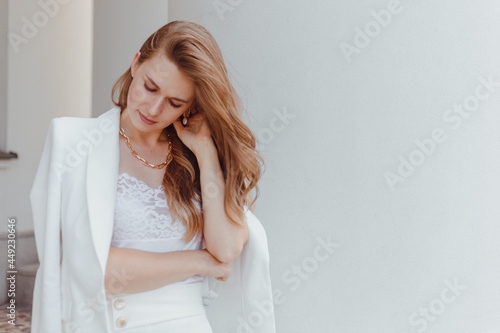 Elegant young woman portrait in while fashion look outdoors