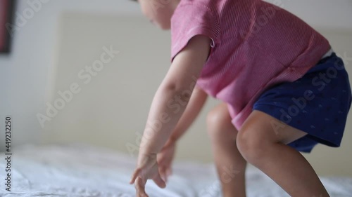 Child jumping into bed. Playful Baby boy getting up and jumps