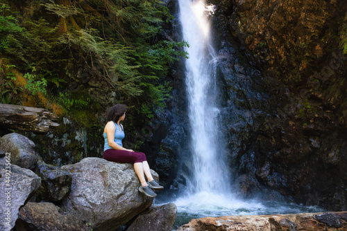 Adult Woman hiker at Norvan Falls and river stream in the natural canyon during the summer time. Canadian Nature Background. Lynn Valley, North Vancouver, BC, Canada. photo