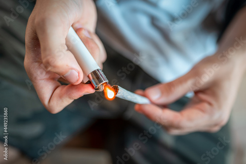 young man heats the hashish to prepare a marijuana cigarette