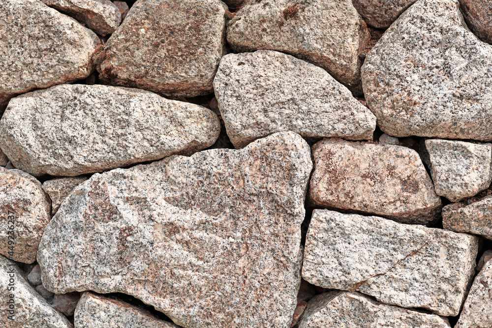 Fototapeta premium Wall with gray and brown irregular different sized and shaped stones