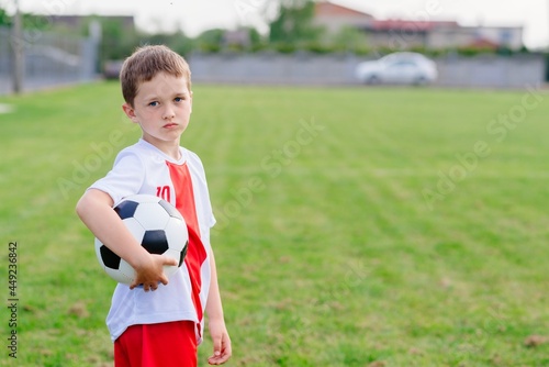 A young boy with a soccer ball on the field. Little soccer player.