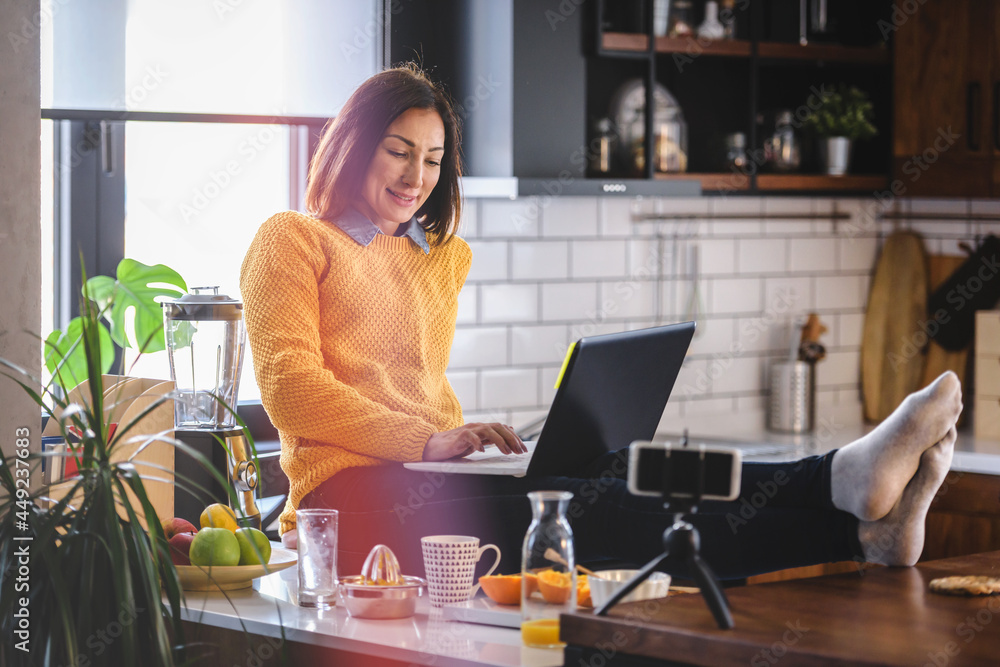 Freelance woman working in home office with laptop computer. Flexible workspace and working time.