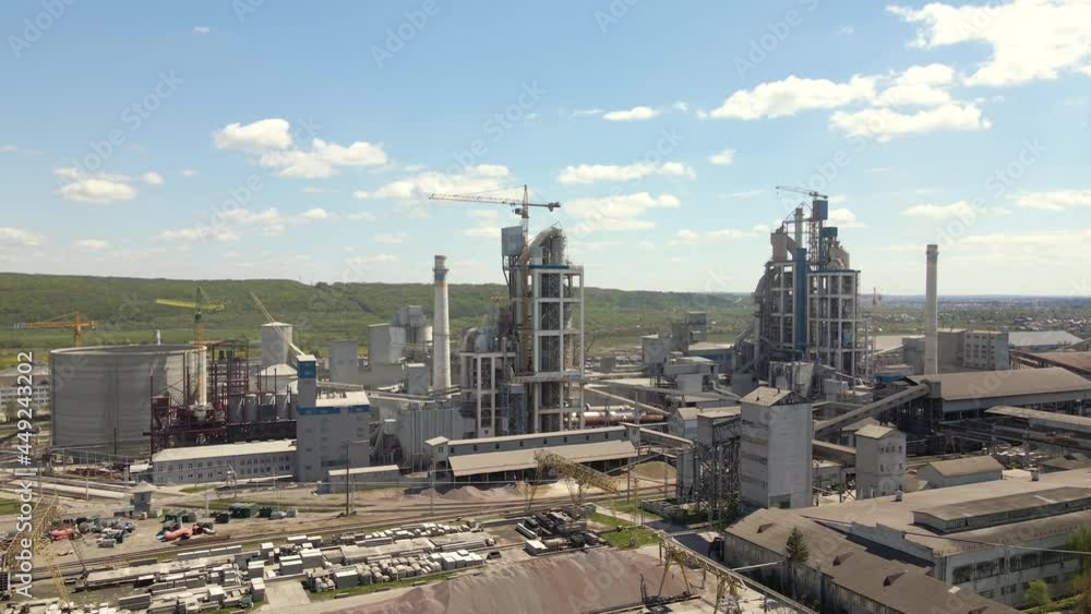 Aerial view of cement plant with high concrete factory structure and tower crane at industrial production area. Manufacture and global industry concept. Aerial view of cement plant with high concrete factory structure and tower crane at industrial production area. Manufacture and global industry concept.