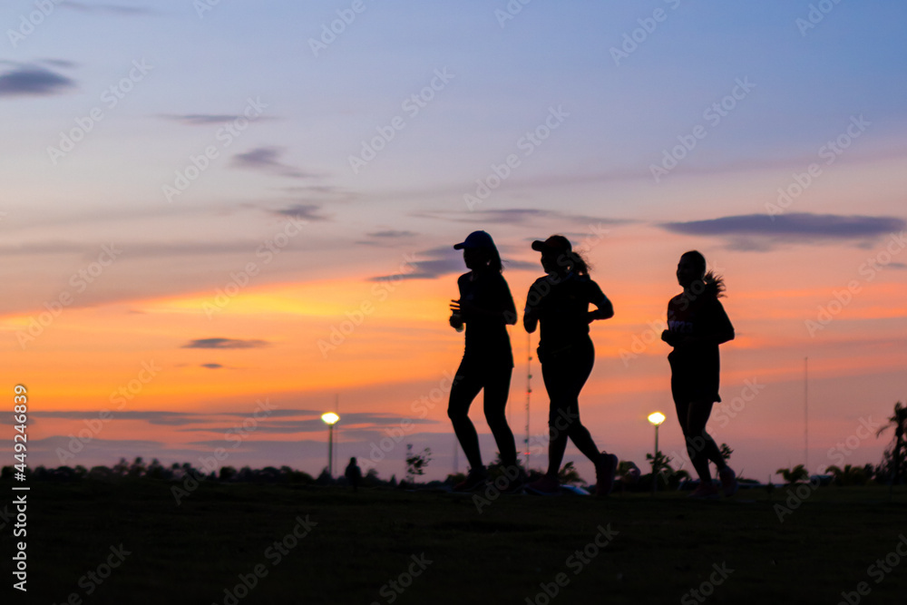 3 women exercising together at sunset
