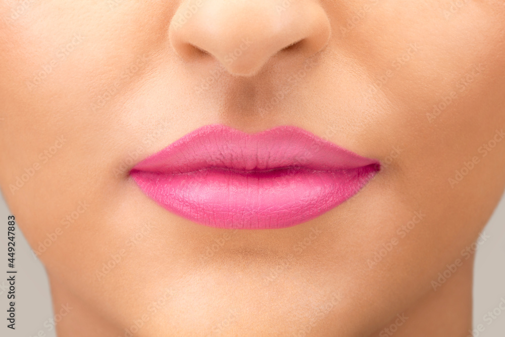 Close up of young caucasian female lips with bright pink lipstick Close up of young caucasian female lips with bright pink lipstick