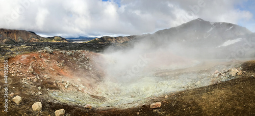 Steam rises above the hot springs of geothermal volcanic zone Landmannalaugar, Iceland.