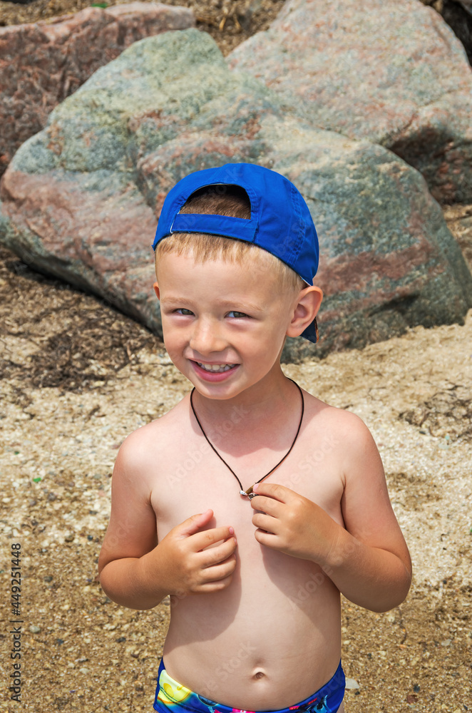 Boy stands and sunbathes on sea beach Boy stands and sunbathes on sea beach