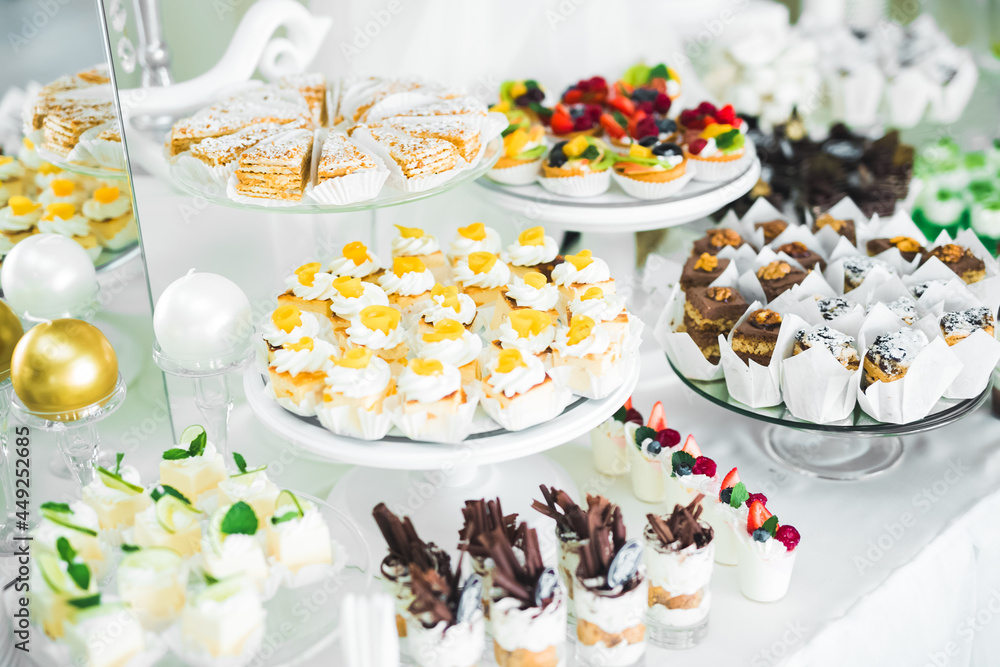 Delicious sweets on wedding candy buffet with desserts, cupcakes Delicious sweets on wedding candy buffet with desserts, cupcakes