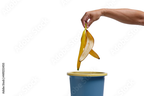 Obraz na plátně In a man hand, banana peel is thrown into trash.Food waste.