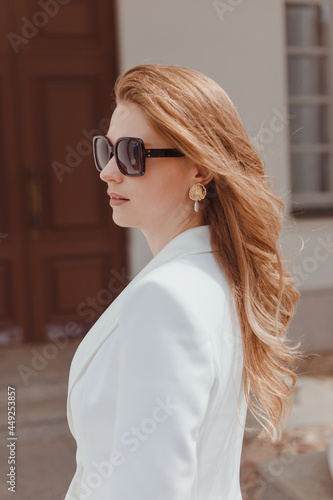 fashion outdoor photo of beautiful young woman looking like elegant lady,wearing white wool coat and accessories.