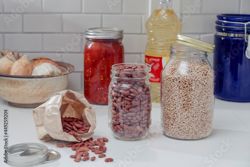 Red beans, tomatoes and grains in jars on a kitchen counter