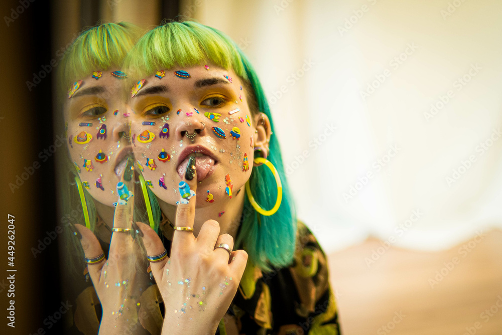 Closeup fashion portrait young pretty beautiful girl with green and blue hair. Beautiful fashion girl with luxury professional makeup and funny emoji stickers glued on the face. Young woman - obrazy, fototapety, plakaty 