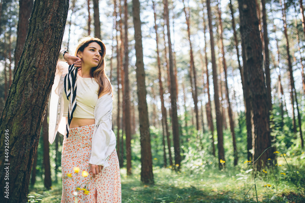 Young beautiful hippie woman walks in the summer forest laughs dances and enjoys life and nature Young beautiful hippie woman walks in the summer forest laughs dances and enjoys life and nature