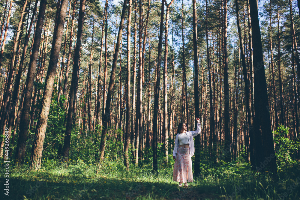 Young beautiful hippie woman walks in the summer forest laughs dances and enjoys life and nature Young beautiful hippie woman walks in the summer forest laughs dances and enjoys life and nature