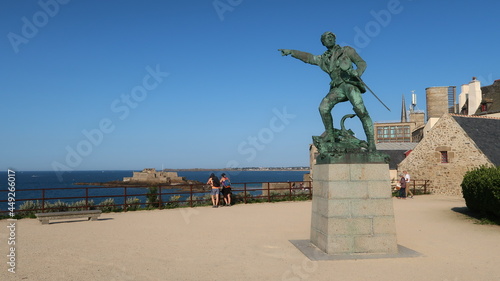 Statue du célèbre corsaire malouin Robert Surcouf sur une place de la ville de Saint-Malo en Bretagne, belvédère avec vue sur la mer, sous un ciel bleu (France)