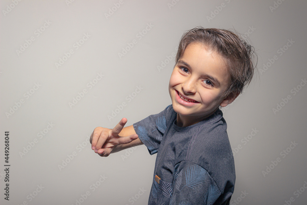 Happy boy showing victory sign isolated on white background Happy boy showing victory sign isolated on white background