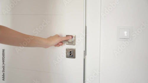 Woman open door lock with a key, open door and leaving out stylish light appartments