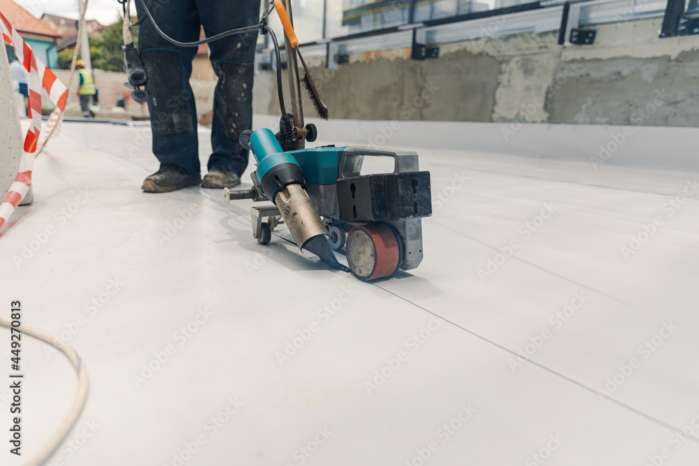 Fototapeta premium Worker welding pvc membrane by heater with welder machine