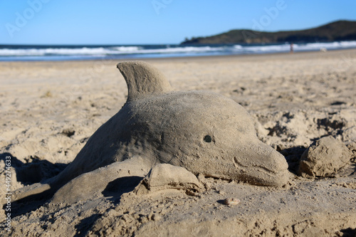 dolphin sand sculpture at the beach