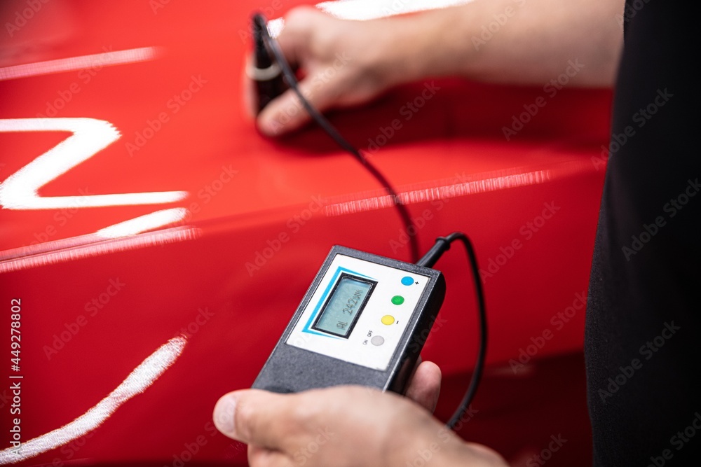 Man checking car paint thickness with electronic meter 素材庫相片 Adobe Stock