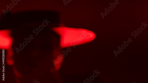 Beautiful hat dressed girl dancing latin dance . Professional female dancer dancing flamenco , rumba or salsa on red background with lines . Spanish dance movements . Shot ARRI ALEXA Cinema Camera .