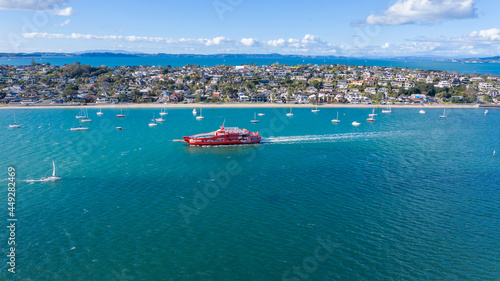 Fototapeta Naklejka Na Ścianę i Meble -  Aerial View from the Beach, Boat, City Streets and Waves - Tahuna Torea, Bucklands Beach View in New Zealand - Auckland Area	