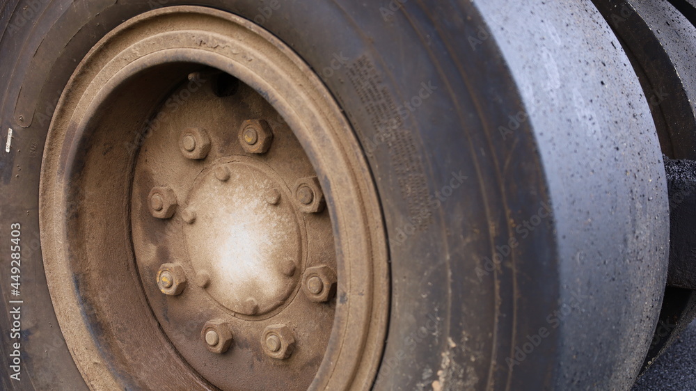 Close up nuts and old wheel hubs. Dirty road roller tires with copy space. Selective focus Close up nuts and old wheel hubs. Dirty road roller tires with copy space. Selective focus