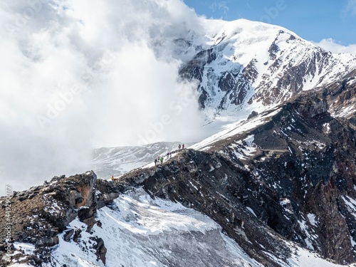 Snow covered mountain under white clouds