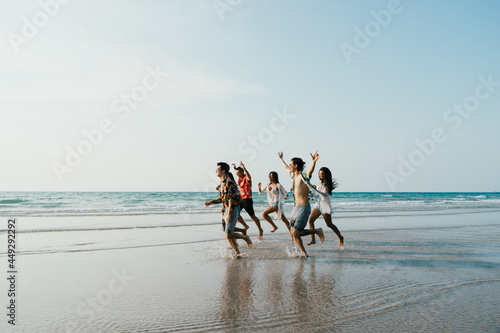 Photography Group of friends running having fun on the white sand beach amid the blue sky
